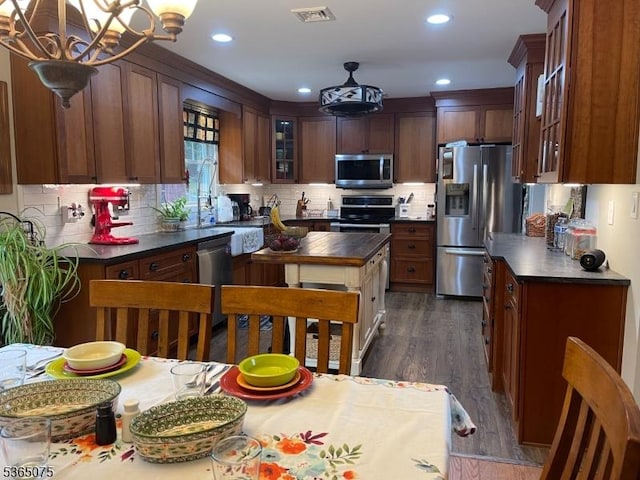 126 Hilltop Trl, Sparta Twp, NJ 07871 - kitchen featuring appliances with stainless steel finishes, a chandelier, glass insert cabinets, dark wood-style flooring, and backsplash