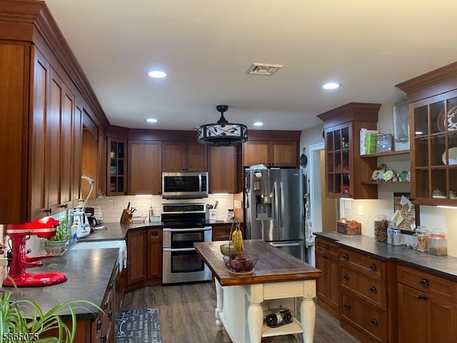 126 Hilltop Trl, Sparta Twp, NJ 07871 - kitchen featuring stainless steel appliances, dark countertops, open shelves, decorative backsplash, and dark wood finished floors