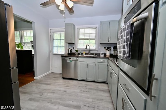 25 Lockwood Ave, Byram Twp, NJ 07874 - kitchen with appliances with stainless steel finishes, dark countertops, a ceiling fan, light wood-type flooring, and gray cabinets