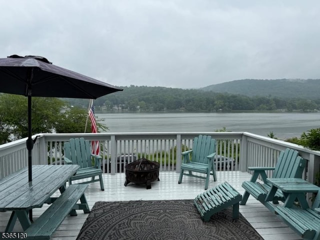 142 Lakeside Dr, Liberty Twp, NJ 07823 - deck with an outdoor fire pit, a water view, and a wooded view