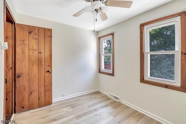76 Hillside Rd, Sparta Twp, NJ 07871 - unfurnished bedroom with multiple windows, light wood-type flooring, and a ceiling fan
