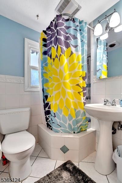 76 Hillside Rd, Sparta Twp, NJ 07871 - bathroom featuring tile walls, tile patterned flooring, shower / bathtub combination with curtain, and a wainscoted wall