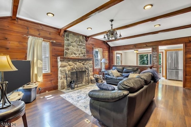 76 Hillside Rd, Sparta Twp, NJ 07871 - living room with wooden walls, wood finished floors, a fireplace, and a chandelier