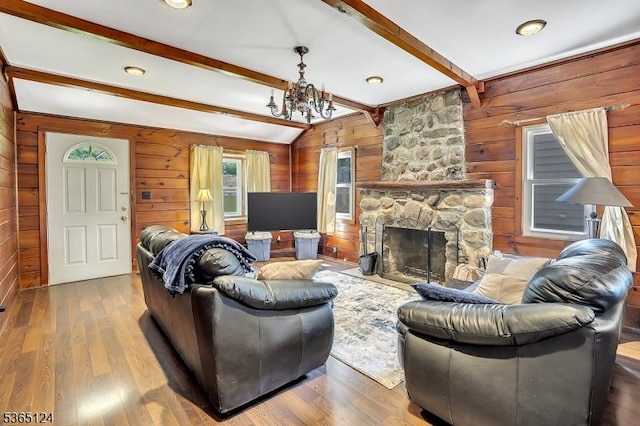 76 Hillside Rd, Sparta Twp, NJ 07871 - living room featuring wooden walls, a chandelier, wood finished floors, and a fireplace