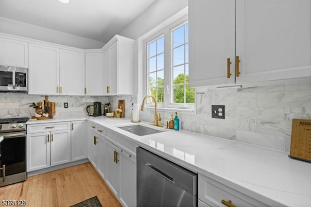 176 Randolph Ave, Mine Hill Twp, NJ 07803 - kitchen featuring stainless steel appliances, white cabinets, decorative backsplash, light wood-style flooring, and light stone countertops