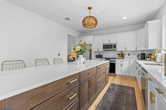 176 Randolph Ave, Mine Hill Twp, NJ 07803 - kitchen with stainless steel appliances, white cabinetry, light wood finished floors, decorative backsplash, and recessed lighting