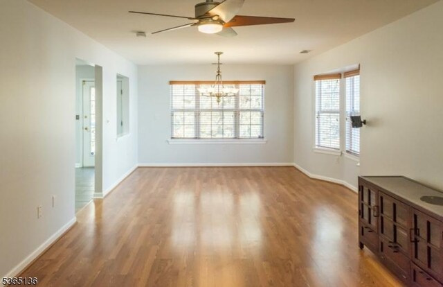 63 Rockcreek Ter, Riverdale Boro, NJ 07457 - empty room with a ceiling fan, wood finished floors, and a chandelier