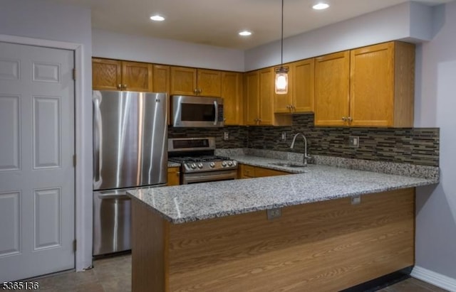 63 Rockcreek Ter, Riverdale Boro, NJ 07457 - kitchen with stainless steel appliances, a peninsula, brown cabinetry, backsplash, and recessed lighting