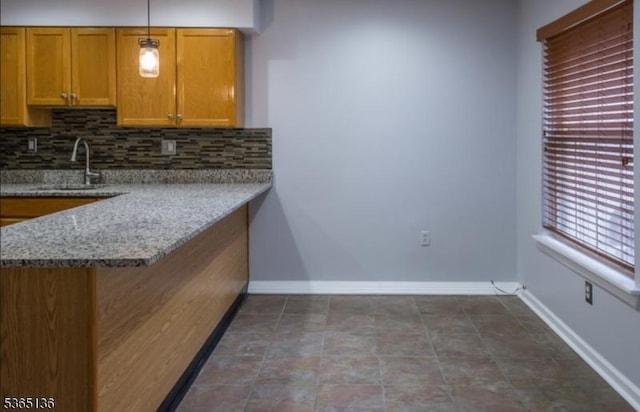 63 Rockcreek Ter, Riverdale Boro, NJ 07457 - kitchen featuring backsplash, pendant lighting, brown cabinetry, light stone counters, and a peninsula