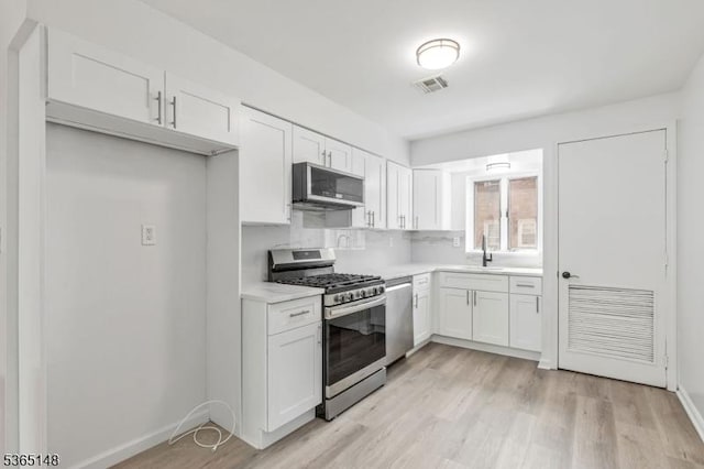 120 Westfield Ave Unit 12, Elizabeth City, NJ 07208 - kitchen featuring stainless steel appliances, white cabinetry, light countertops, and light wood-style flooring