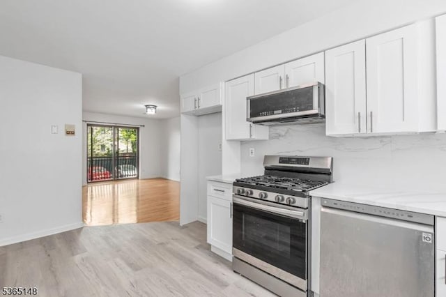 120 Westfield Ave Unit 12, Elizabeth City, NJ 07208 - kitchen featuring stainless steel appliances, light countertops, white cabinetry, light wood-type flooring, and tasteful backsplash