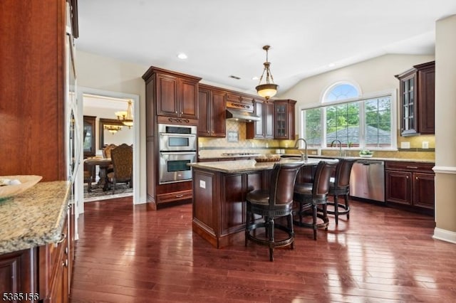6 Cope Ct, Hillsborough Twp, NJ 08844 - kitchen with stainless steel appliances, an island with sink, dark wood-type flooring, vaulted ceiling, and decorative backsplash