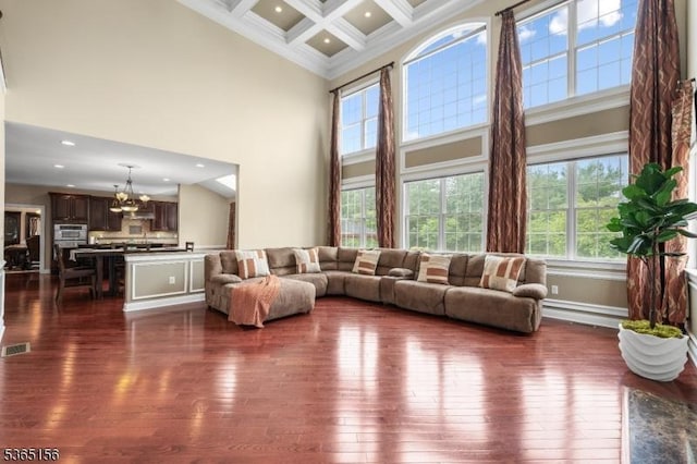 6 Cope Ct, Hillsborough Twp, NJ 08844 - living room featuring a towering ceiling, a chandelier, dark wood finished floors, beam ceiling, and crown molding