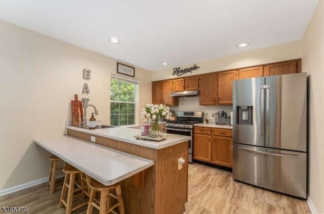 149 Wingate Dr, Independence Twp, NJ 07840 - kitchen with appliances with stainless steel finishes, under cabinet range hood, brown cabinets, light wood-style floors, and recessed lighting