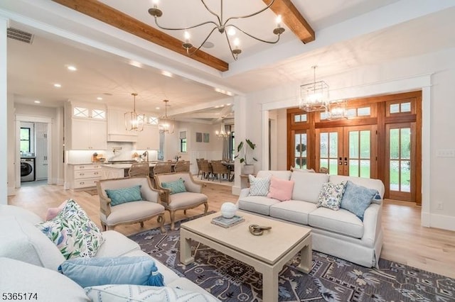 2 County Line Rd, Mendham Boro, NJ 07945 - living area featuring a chandelier, washer / clothes dryer, beam ceiling, light wood-style floors, and french doors