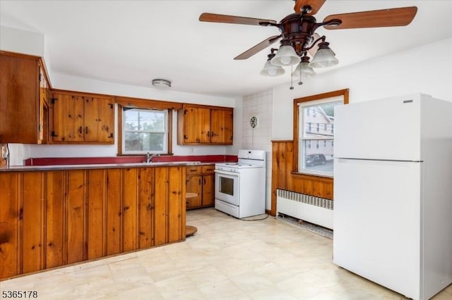 267 William St, Belleville Twp, NJ 07109 - kitchen with white appliances, radiator, brown cabinets, and healthy amount of natural light