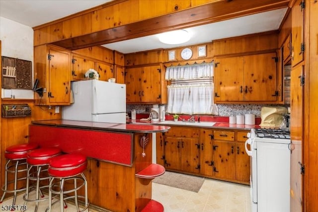 267 William St, Belleville Twp, NJ 07109 - kitchen featuring white appliances, brown cabinetry, tasteful backsplash, and wooden walls