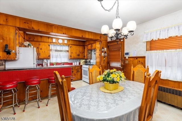267 William St, Belleville Twp, NJ 07109 - dining area featuring radiator, a chandelier, light floors, and wooden walls