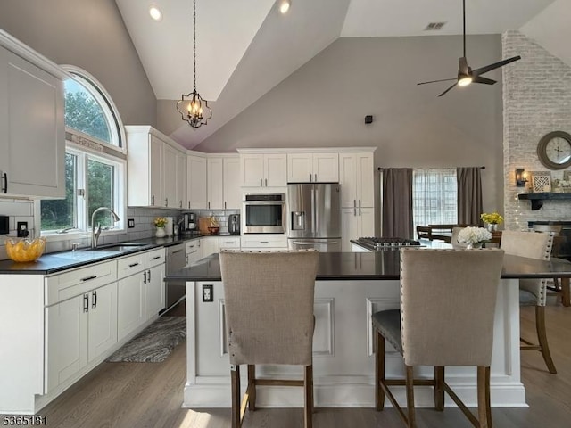 26 Knollwood Rd, Hanover Twp, NJ 07981 - kitchen featuring stainless steel appliances, dark countertops, high vaulted ceiling, white cabinets, and dark wood finished floors
