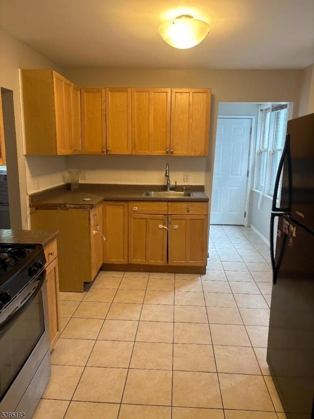 552 Liberty St, City Of Orange Twp, NJ 07050 - kitchen with freestanding refrigerator, stainless steel range oven, light tile patterned flooring, and dark countertops
