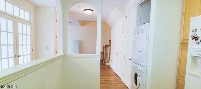 228 Windmill Ct, Lopatcong Twp, NJ 08865 - laundry area featuring stacked washer / drying machine, light wood-style floors, and arched walkways