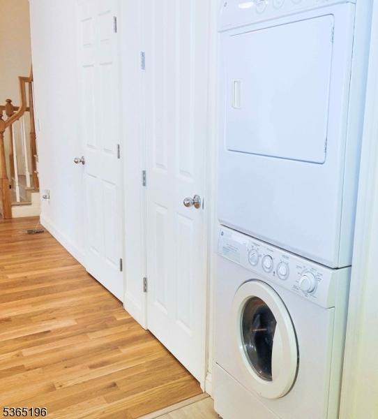 228 Windmill Ct, Lopatcong Twp, NJ 08865 - laundry room featuring estacked washer and dryer and light wood-type flooring
