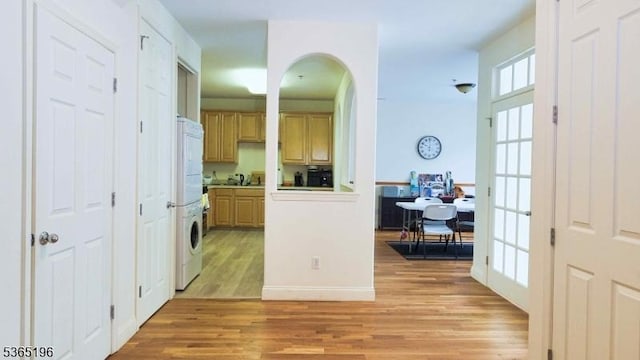 228 Windmill Ct, Lopatcong Twp, NJ 08865 - entrance foyer with light wood-type flooring, stacked washer and clothes dryer, and arched walkways