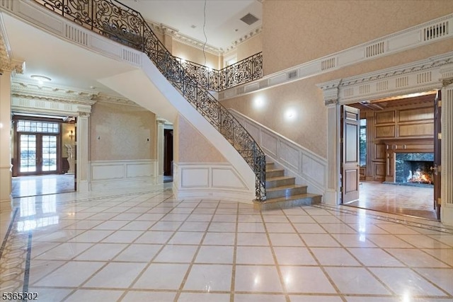 11 Margo Way, Alpine Boro, NJ 07620 - staircase featuring a decorative wall, inlaid floor details, crown molding, a premium fireplace, and french doors