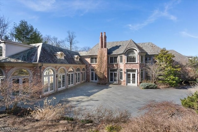 11 Margo Way, Alpine Boro, NJ 07620 - rear view of property with french doors, a chimney, a patio, a high end roof, and brick siding