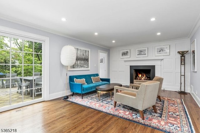 95 Green Ave, Madison Boro, NJ 07940 - living area featuring crown molding, wood finished floors, a warm lit fireplace, and recessed lighting