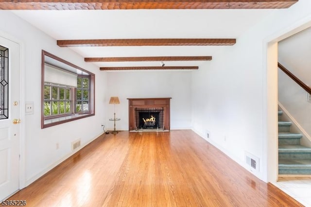 2538 Mountain Ave, Scotch Plains Twp, NJ 07076 - unfurnished living room with light wood-style floors, stairway, a brick fireplace, and beam ceiling