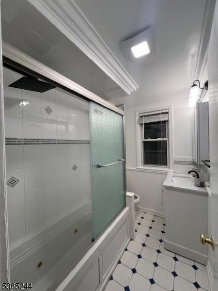 14 Guenther Pl, Passaic City, NJ 07055 - bathroom featuring vanity, a combined bath / shower with jetted tub, crown molding, and a wainscoted wall