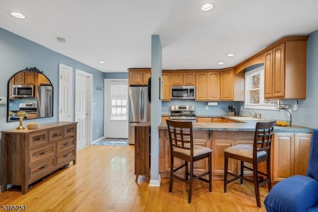 67 Riverview Ave, Lincoln Park Boro, NJ 07035 - kitchen with stainless steel appliances, light wood finished floors, a peninsula, recessed lighting, and brown cabinetry