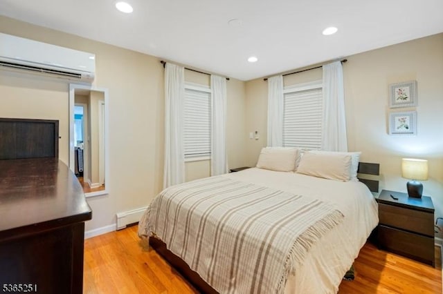 67 Riverview Ave, Lincoln Park Boro, NJ 07035 - bedroom with a wall unit AC, a baseboard heating unit, light wood-style floors, and recessed lighting