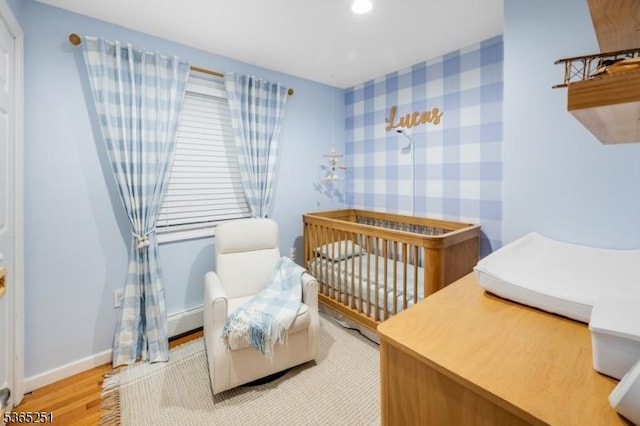 67 Riverview Ave, Lincoln Park Boro, NJ 07035 - bedroom with wood finished floors, wallpapered walls, recessed lighting, and a nursery area