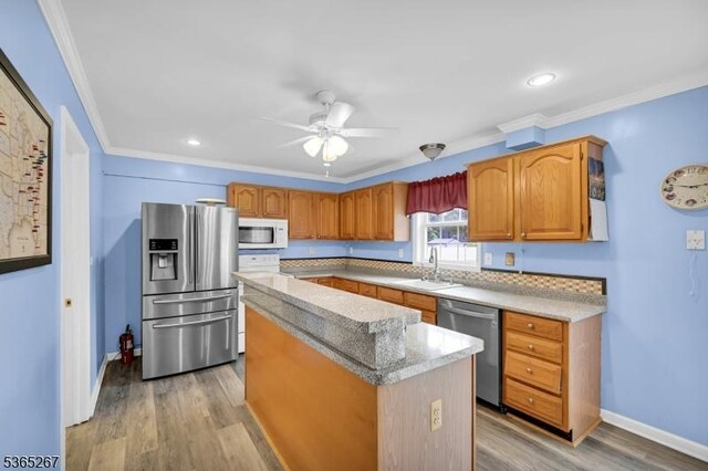 8 Dahn Dr, Sparta Twp, NJ 07871 - kitchen featuring stainless steel appliances, a kitchen island, ornamental molding, ceiling fan, and light wood-style floors