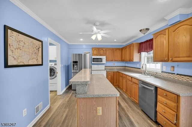 8 Dahn Dr, Sparta Twp, NJ 07871 - kitchen featuring stainless steel appliances, washer / clothes dryer, a center island, a ceiling fan, and light wood-type flooring
