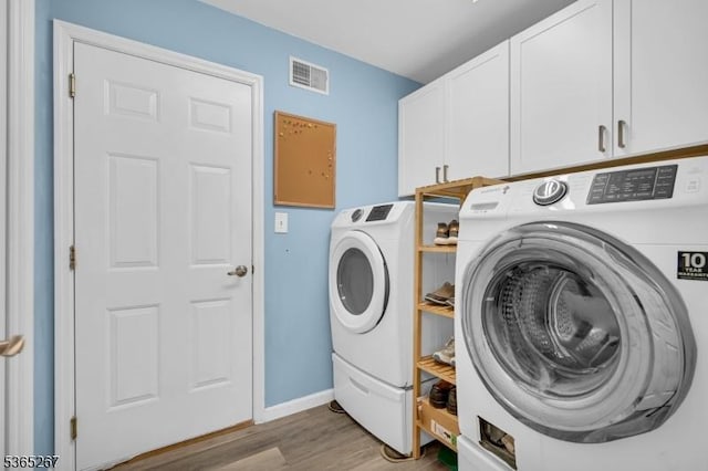 8 Dahn Dr, Sparta Twp, NJ 07871 - laundry area with washer and clothes dryer, cabinet space, and light wood finished floors