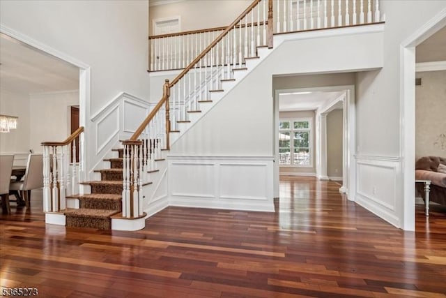 7 Sycamore Dr, Chatham Twp, NJ 07928 - staircase with a decorative wall, wood-type flooring, ornamental molding, a high ceiling, and a chandelier