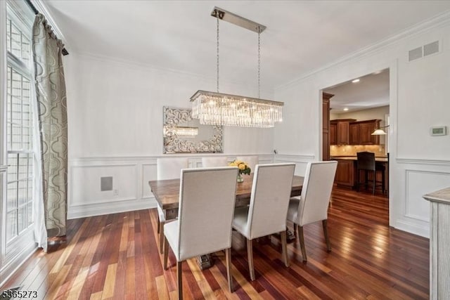 7 Sycamore Dr, Chatham Twp, NJ 07928 - dining area with dark wood-style floors, a decorative wall, healthy amount of natural light, a chandelier, and crown molding