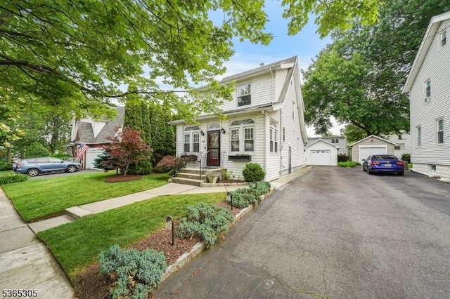103 Cedar St, Nutley Twp, NJ 07110 - view of front of home with a detached garage, a front yard, an outdoor structure, and driveway