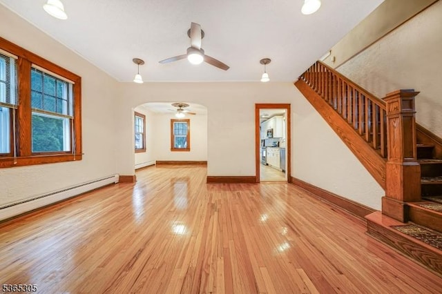 103 Cedar St, Nutley Twp, NJ 07110 - unfurnished living room with ceiling fan, light wood-style flooring, arched walkways, stairs, and a baseboard radiator