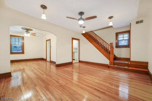 103 Cedar St, Nutley Twp, NJ 07110 - unfurnished living room featuring ceiling fan, light wood-style floors, stairs, and arched walkways