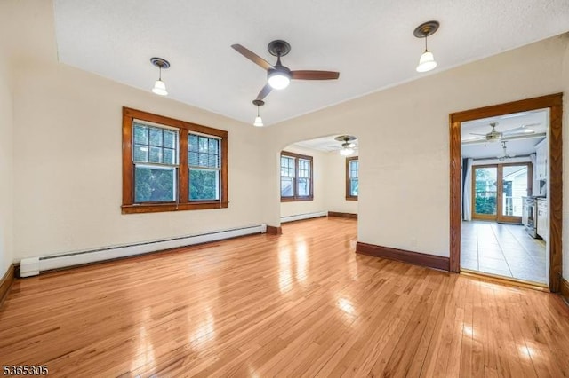 103 Cedar St, Nutley Twp, NJ 07110 - spare room featuring a baseboard heating unit, a ceiling fan, baseboard heating, light wood-style floors, and arched walkways