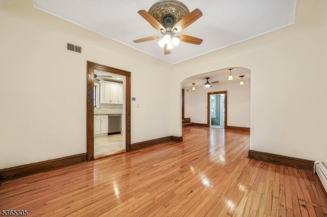 103 Cedar St, Nutley Twp, NJ 07110 - empty room featuring arched walkways, ceiling fan, light wood-type flooring, and a baseboard radiator