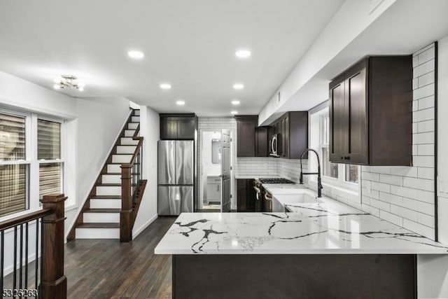 613 S 18th St, Newark City, NJ 07103 - kitchen featuring stainless steel appliances, dark brown cabinets, recessed lighting, backsplash, and light stone countertops