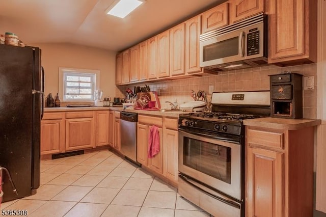 104 W Emerson Ave, Rahway City, NJ 07065 - kitchen with appliances with stainless steel finishes, vaulted ceiling, light tile patterned floors, tasteful backsplash, and light countertops