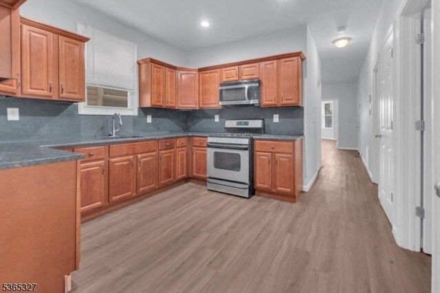 160 S 11th St, Newark City, NJ 07107 - kitchen featuring appliances with stainless steel finishes, light wood-type flooring, decorative backsplash, brown cabinets, and recessed lighting
