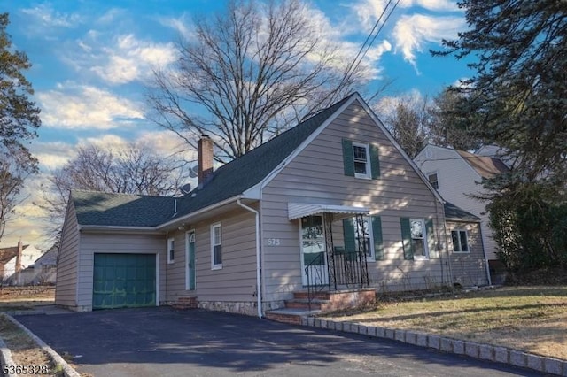573 Conant St, Hillside Twp, NJ 07205 - view of front of property featuring a garage, asphalt driveway, and a chimney