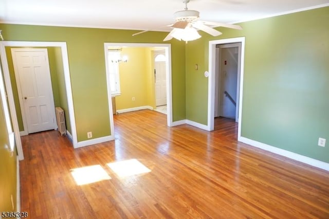 573 Conant St, Hillside Twp, NJ 07205 - spare room featuring radiator heating unit, ceiling fan, light wood-type flooring, a chandelier, and ornamental molding